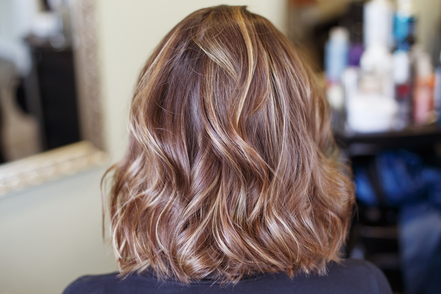 A woman with beautiful brown styled hair seen from the back. Concept of celebrity hair, hair loss, hair loss concealers, hair stylist.